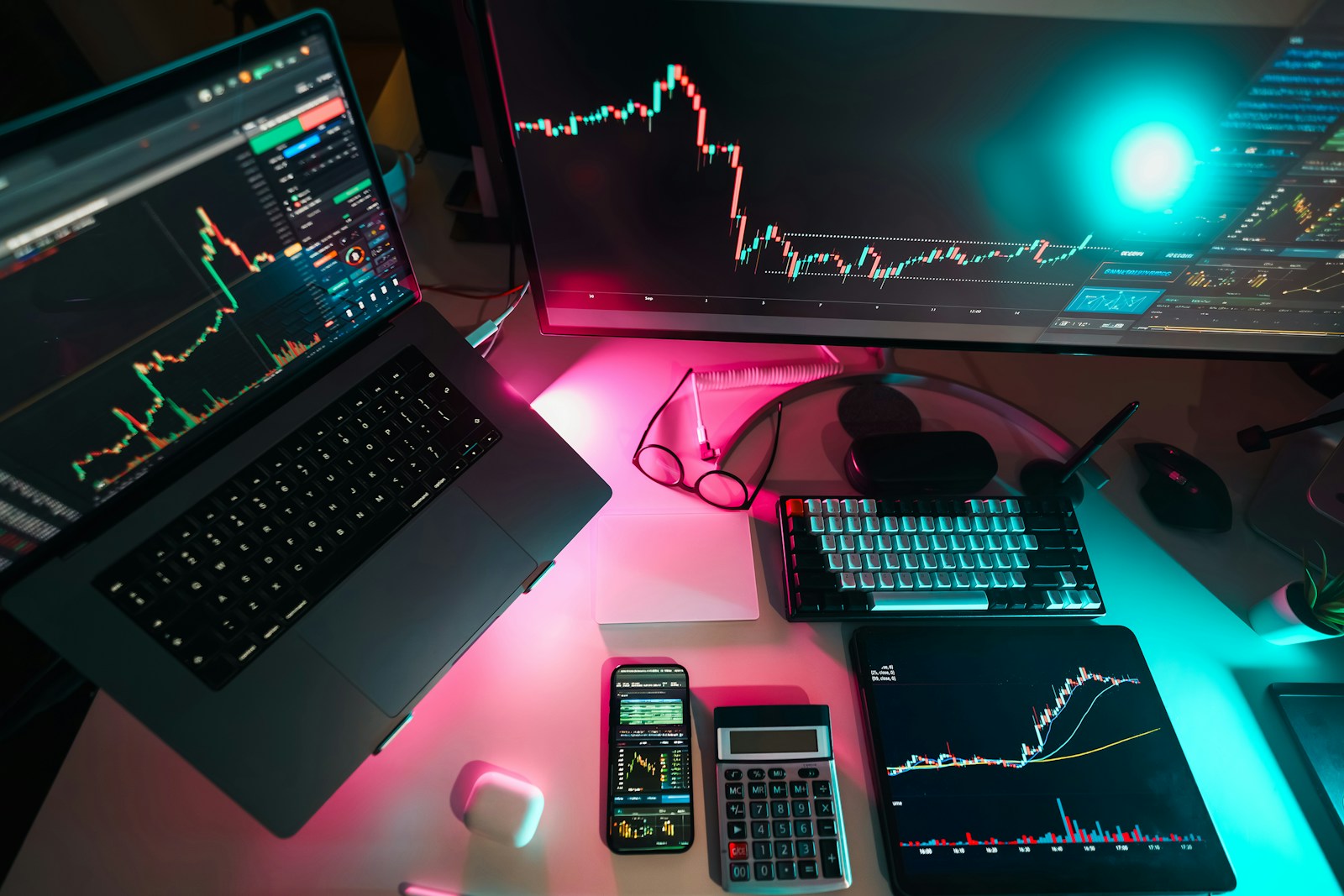 Digital marketing performance charts displayed across laptop and monitor screens